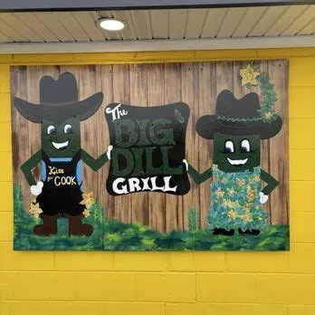 Hand-painted mural of two cowboy pickles on the yellow wall at The Big Dill Grill